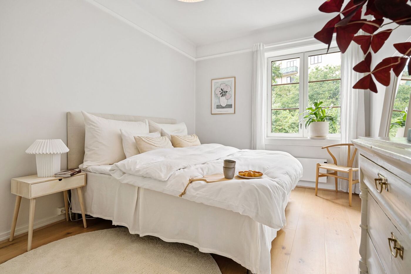 Dormitorio luminoso con ropa de cama blanca y ventana