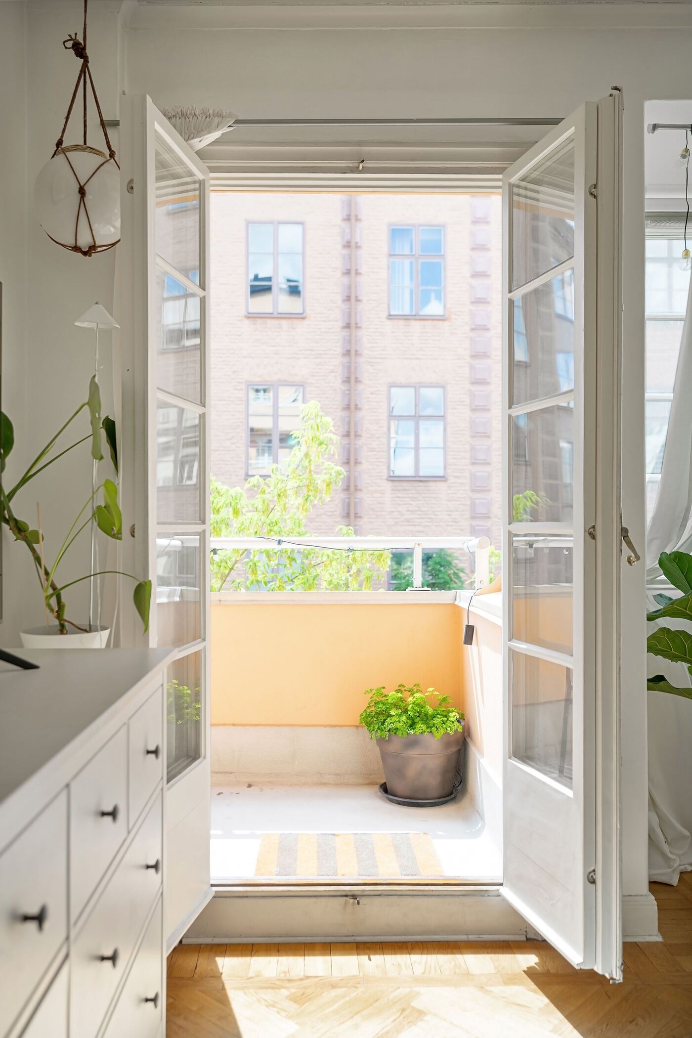Puertas acristaladas abiertas a un balcón con plantas