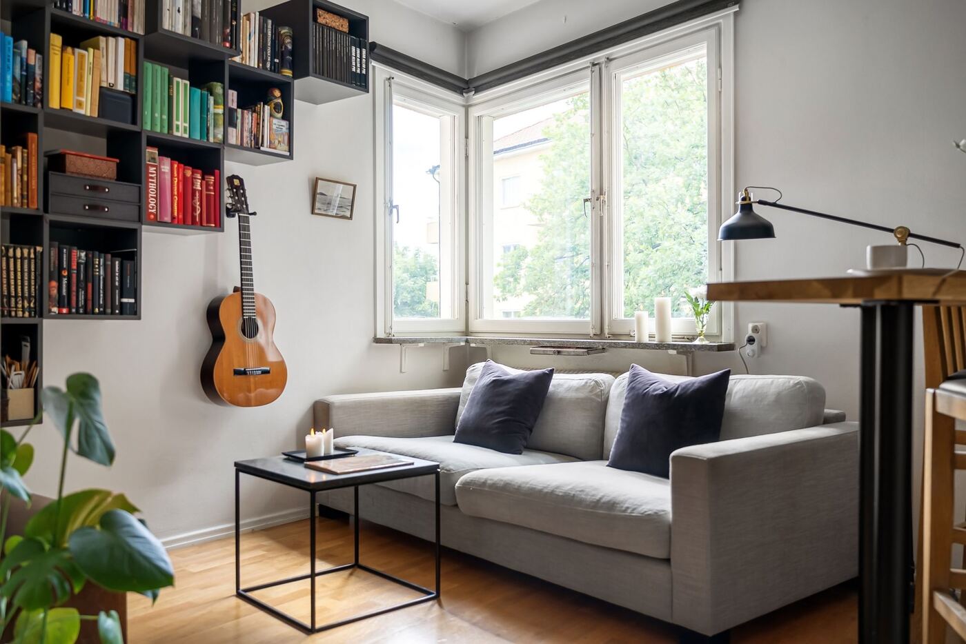 Salón con estanterías de colores y guitarra en la pared